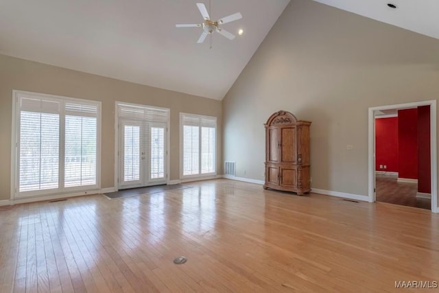 unfurnished living room featuring ceiling fan, french doors, high vaulted ceiling, and light hardwood / wood-style floors