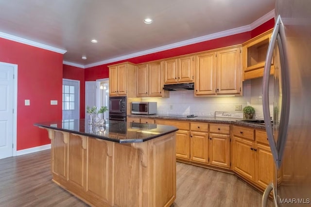 kitchen with a center island, a kitchen breakfast bar, crown molding, black appliances, and light wood-type flooring