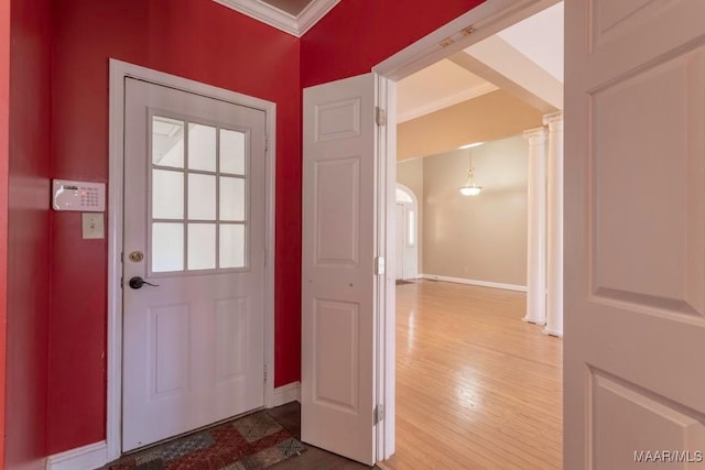 entryway with hardwood / wood-style floors, ornate columns, and ornamental molding