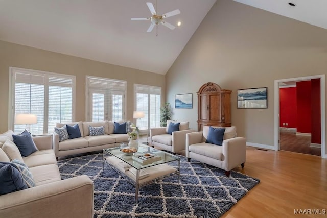 living room with hardwood / wood-style floors, high vaulted ceiling, and ceiling fan