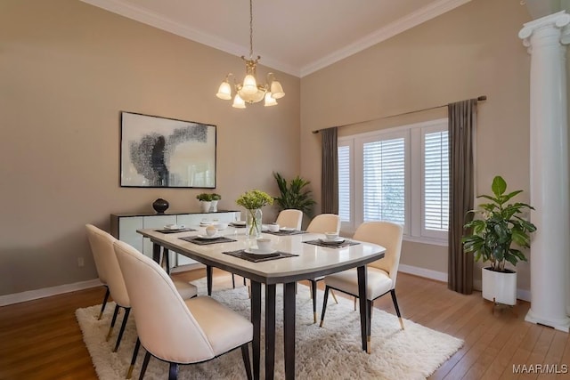 dining room with ornate columns, wood-type flooring, a chandelier, and ornamental molding