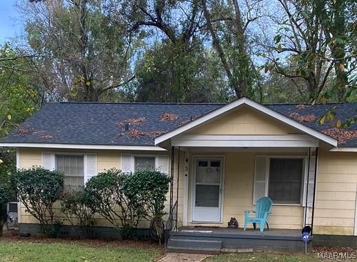 single story home featuring covered porch and a front yard