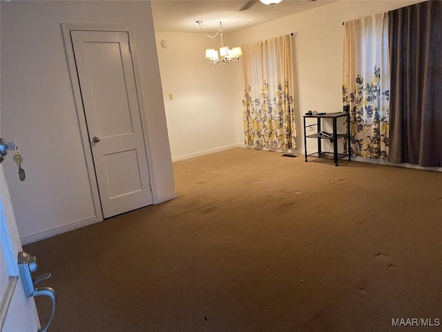 carpeted spare room with a notable chandelier