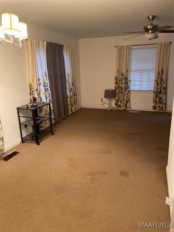 interior space featuring ceiling fan with notable chandelier