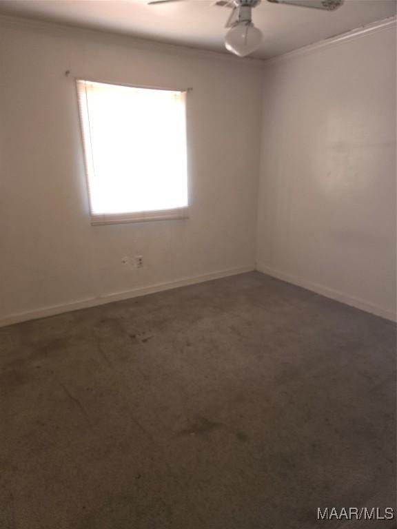 empty room featuring dark carpet and crown molding