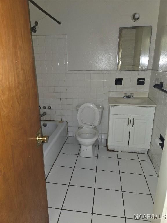 full bathroom with vanity, tile patterned floors, toilet, shower / bathing tub combination, and tile walls