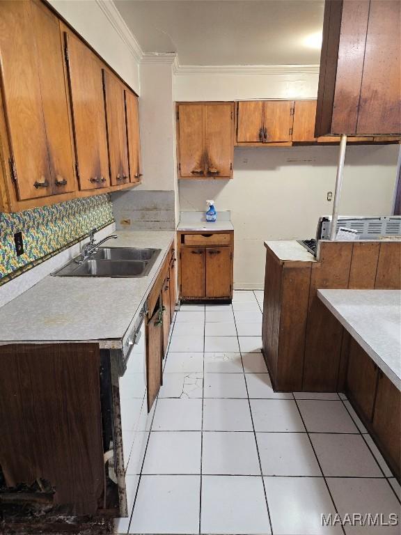 kitchen featuring crown molding, sink, white dishwasher, and light tile patterned flooring