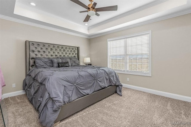 carpeted bedroom with a tray ceiling, ceiling fan, and crown molding