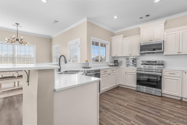 kitchen featuring kitchen peninsula, stainless steel appliances, white cabinetry, and a notable chandelier