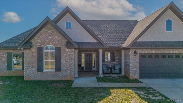 view of front facade with a porch, a garage, and a front yard