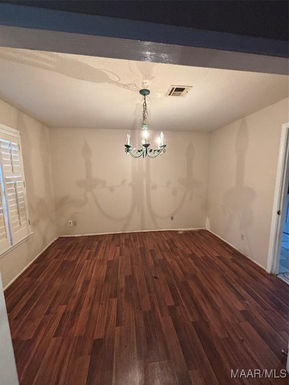 unfurnished dining area featuring dark hardwood / wood-style flooring and a chandelier