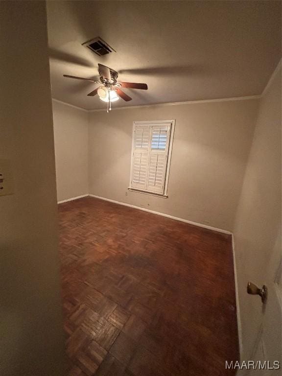 spare room with dark parquet floors, ceiling fan, and crown molding