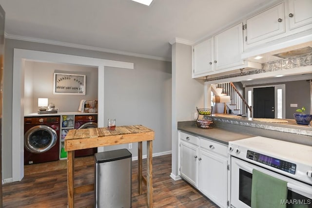 kitchen with dark hardwood / wood-style floors, stove, washer and clothes dryer, white cabinets, and ornamental molding