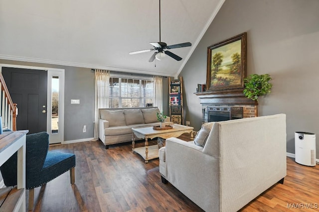 living room featuring dark hardwood / wood-style floors, ceiling fan, ornamental molding, and vaulted ceiling