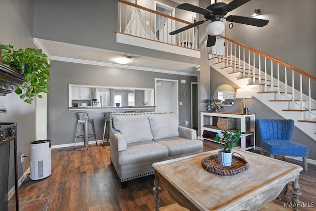 living room featuring ceiling fan, dark hardwood / wood-style flooring, and crown molding