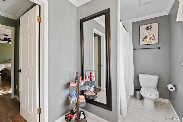 bathroom featuring crown molding and toilet