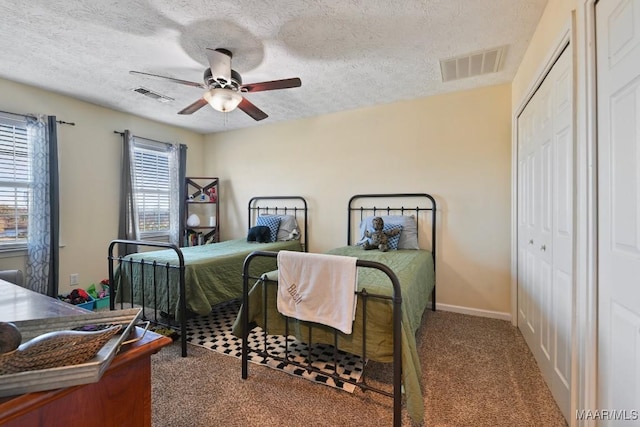 bedroom with carpet flooring, a textured ceiling, a closet, and ceiling fan