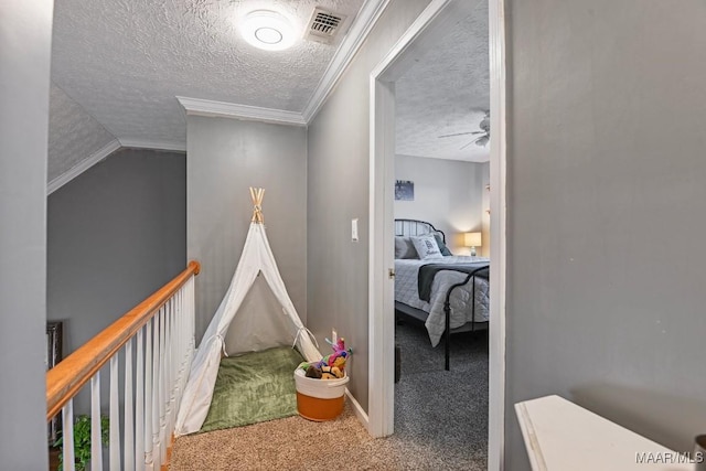 hall featuring carpet flooring, a textured ceiling, and ornamental molding