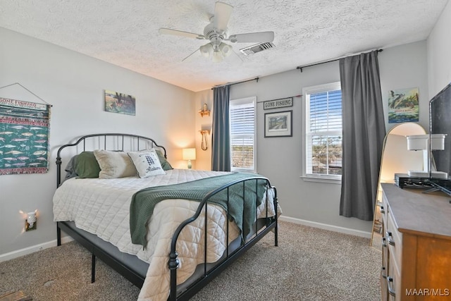 carpeted bedroom featuring ceiling fan and a textured ceiling