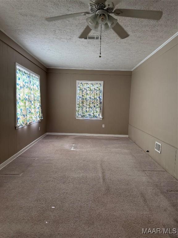 unfurnished room with carpet flooring, ceiling fan, a textured ceiling, and ornamental molding