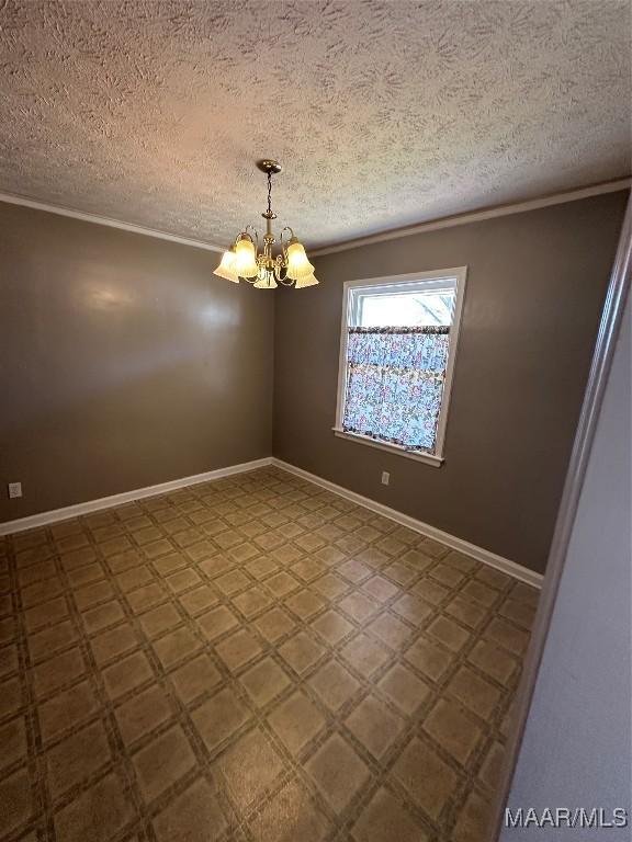empty room with a chandelier and a textured ceiling