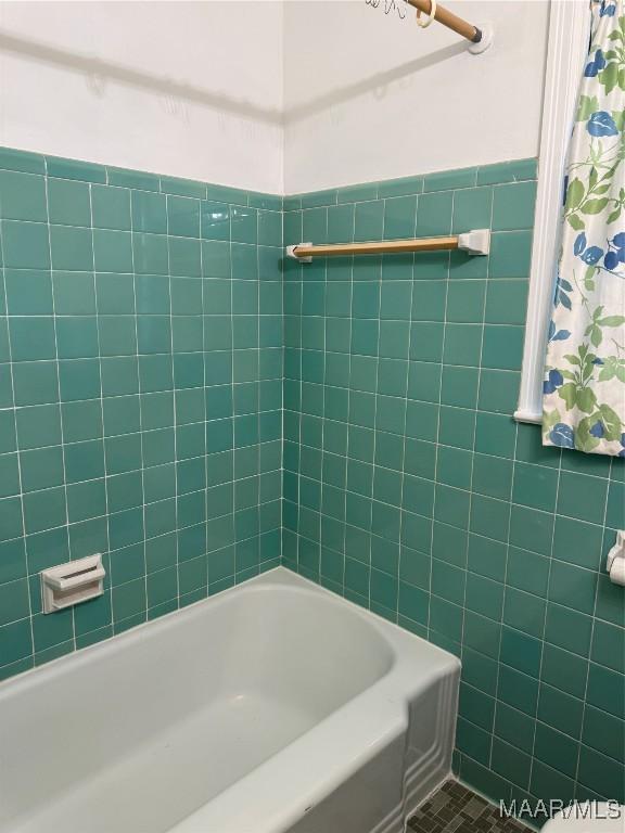 bathroom with tile patterned floors, shower / bathtub combination, and tile walls