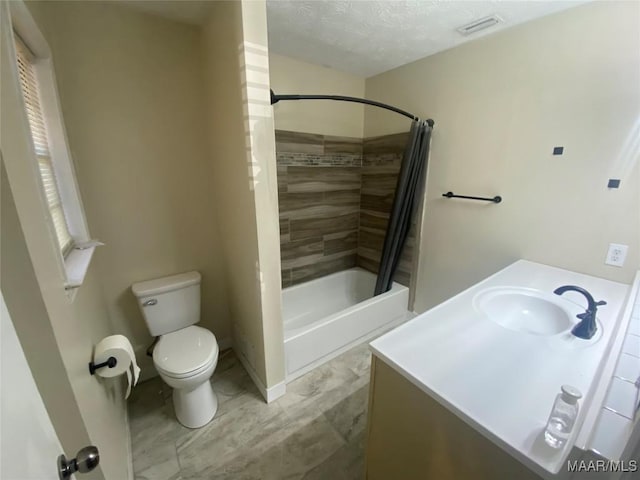 full bathroom featuring shower / bath combo with shower curtain, vanity, a textured ceiling, and toilet