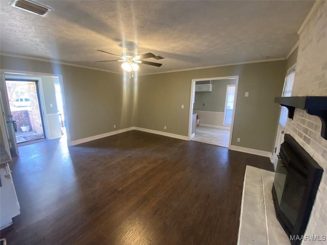 unfurnished living room with crown molding, a brick fireplace, ceiling fan, a textured ceiling, and dark hardwood / wood-style flooring