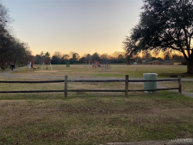 yard at dusk featuring a playground