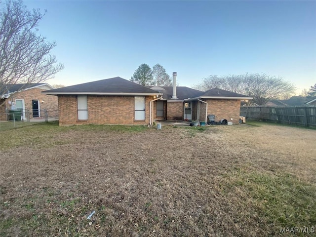 rear view of property featuring a lawn