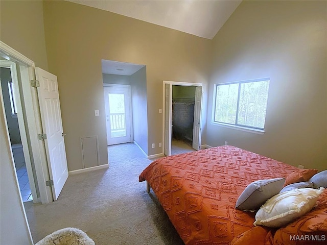 carpeted bedroom with a spacious closet, high vaulted ceiling, and a closet