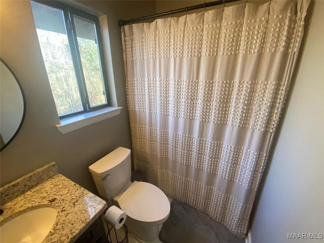 bathroom featuring a shower with curtain, vanity, and toilet