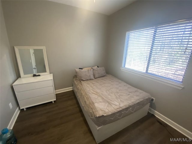 bedroom with dark hardwood / wood-style flooring