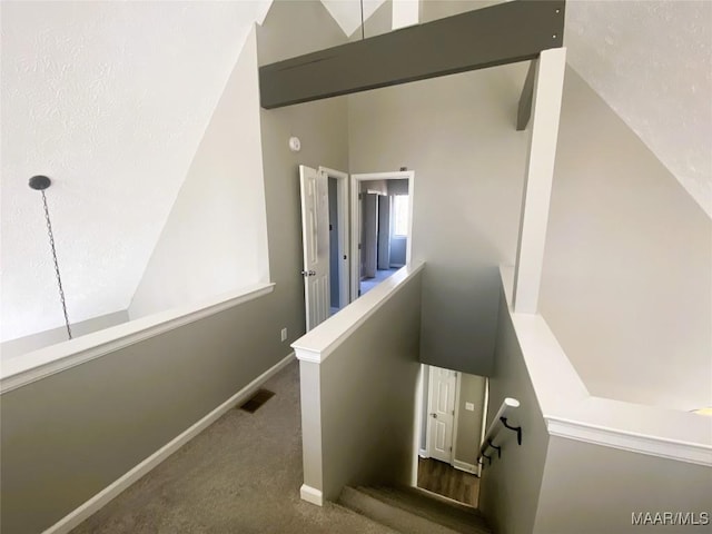 stairway with carpet flooring and high vaulted ceiling