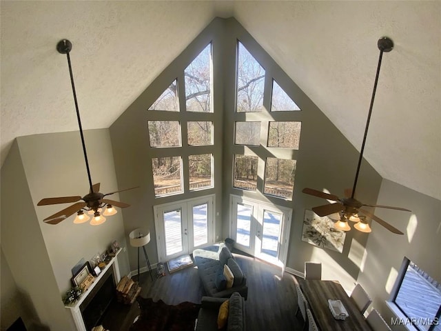 details featuring a fireplace, ceiling fan, french doors, and a textured ceiling