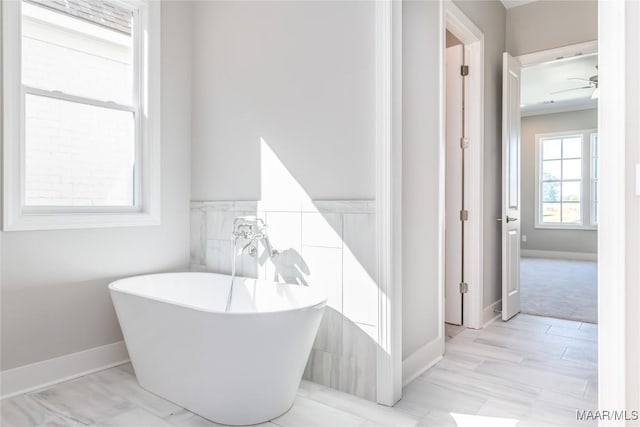 bathroom with ceiling fan and a tub