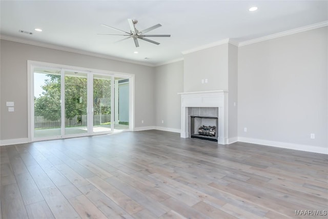 unfurnished living room with light wood-type flooring, ceiling fan, ornamental molding, and a tiled fireplace