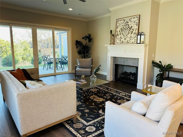 living room featuring ornamental molding, dark wood-type flooring, and a tiled fireplace