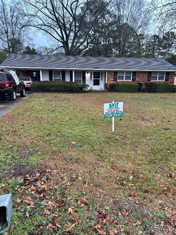 single story home with a front yard and a carport