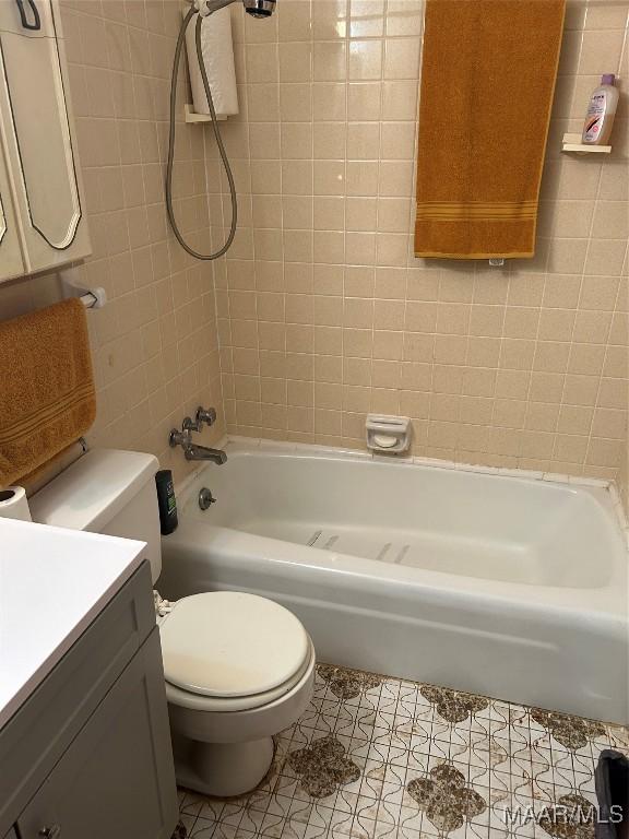 full bathroom with tile patterned flooring, vanity, toilet, and tiled shower / bath