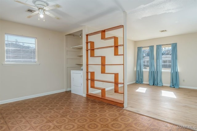 unfurnished room featuring ceiling fan and washer / dryer