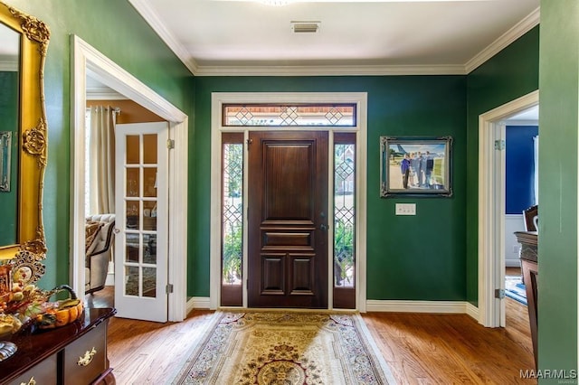 entryway featuring ornamental molding and light hardwood / wood-style flooring