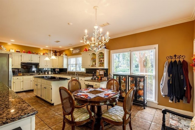 tiled dining area featuring an inviting chandelier and crown molding