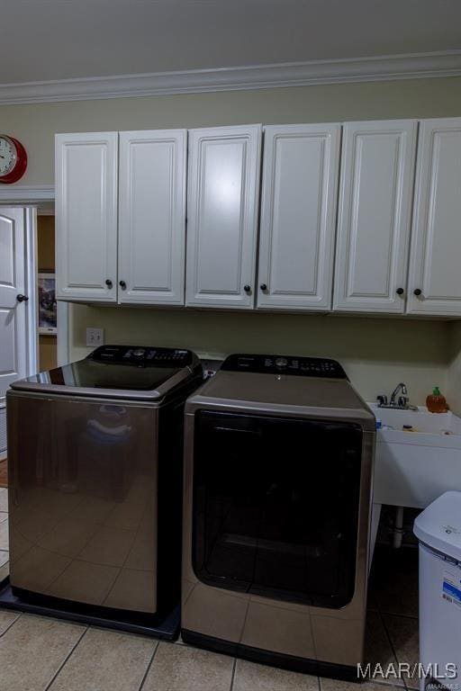 laundry room featuring cabinets, light tile patterned floors, washer and dryer, and ornamental molding