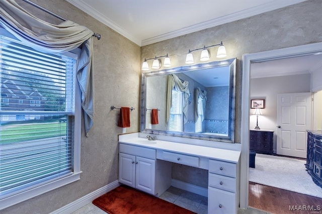 bathroom featuring a wealth of natural light, tile patterned flooring, vanity, and ornamental molding