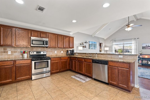 kitchen featuring ceiling fan, stainless steel appliances, lofted ceiling with beams, kitchen peninsula, and decorative backsplash