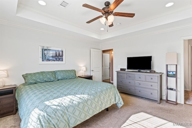 bedroom featuring ceiling fan, ornamental molding, light carpet, and a tray ceiling