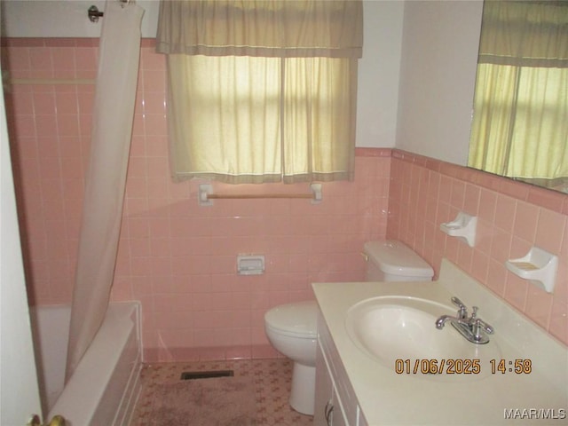 full bathroom with vanity, shower / bath combo, tile patterned flooring, toilet, and tile walls