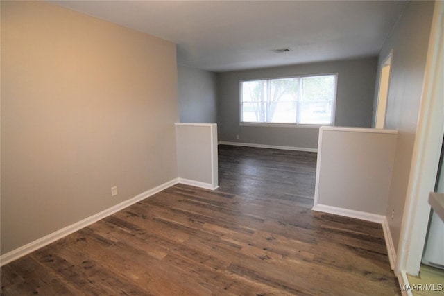 unfurnished room featuring dark wood-type flooring