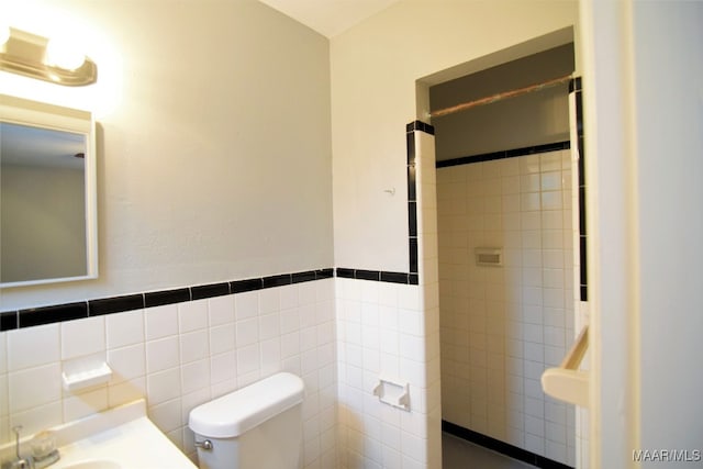 bathroom featuring toilet and tile walls